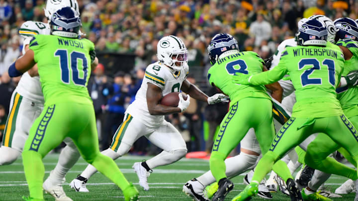 Dec 15, 2024; Seattle, Washington, USA; Green Bay Packers running back Josh Jacobs (8) carries the ball and later scores a touchdown against the Seattle Seahawks during the first half at Lumen Field. Mandatory Credit: Steven Bisig-Imagn Images
