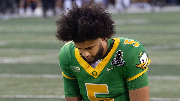 Oregon quarterback Dante Moore bows in prayer before the game against James Madison at Autzen Stadium in Eugene Dec. 20, 2025.