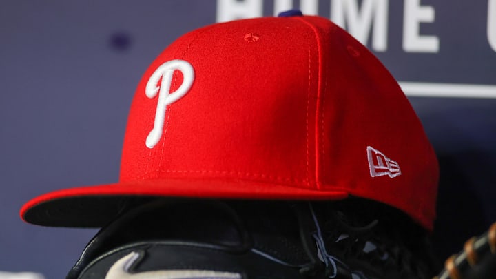 May 26, 2023; Atlanta, Georgia, USA; A detailed view of a Philadelphia Phillies hat and glove on the bench against the Atlanta Braves in the seventh inning at Truist Park. 