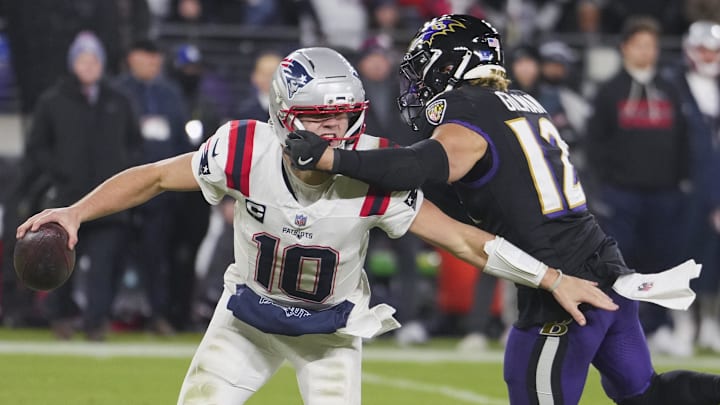 Dec 21, 2025; Baltimore, Maryland, USA;  New England Patriots quarterback Drake Maye (10) scrambles against Baltimore Ravens safety Alohi Gilman (12) during the second half of the game at M&T Bank Stadium. Mandatory Credit: Mitch Stringer-Imagn Images