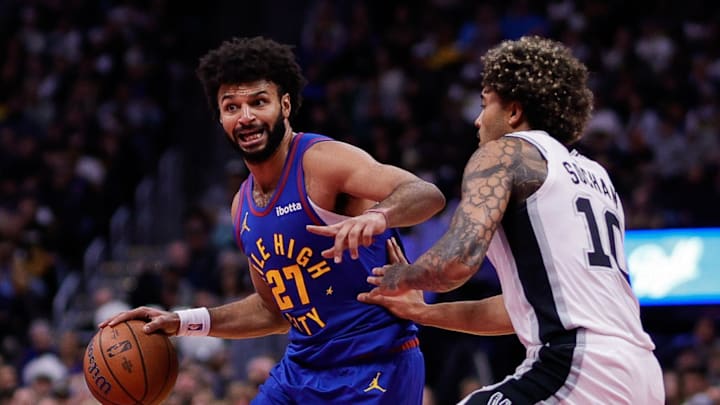 Nov 28, 2025; Denver, Colorado, USA; Denver Nuggets guard Jamal Murray (27) controls the ball as San Antonio Spurs forward Jeremy Sochan (10) guards in the second quarter at Ball Arena.