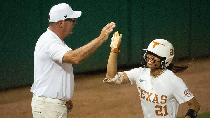 Texas Longhorns head coach Mike White high fives Kayden Henry after she hit a long home run.