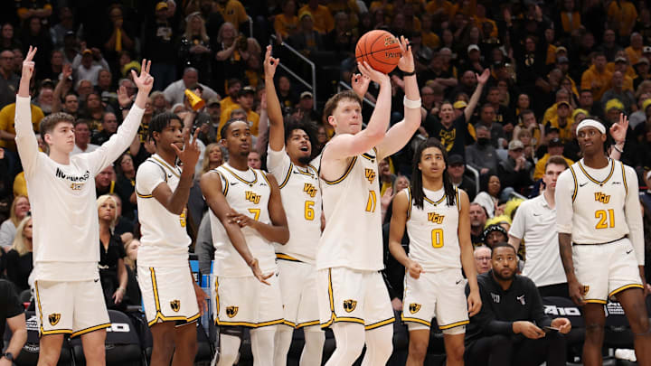 The VCU bench cheers on Max Shulga in the Atlantic 10 championship.