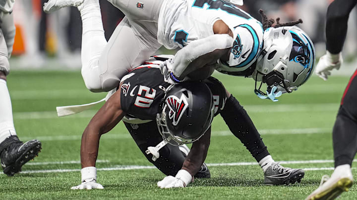 Jan 5, 2025; Atlanta, Georgia, USA; Carolina Panthers running back Mike Boone (34) is upended by Atlanta Falcons cornerback Dee Alford (20) during the second half at Mercedes-Benz Stadium. Mandatory Credit: Dale Zanine-Imagn Images