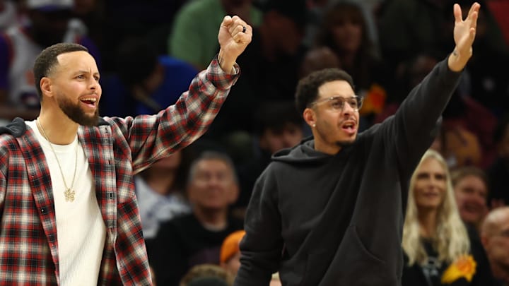 Feb 5, 2026; Phoenix, Arizona, USA; Golden State Warriors guard Stephen Curry (left) and brother Seth Curry react against the Phoenix Suns in the second half at Mortgage Matchup Center. Mandatory Credit: Mark J. Rebilas-Imagn Images