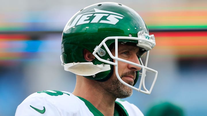 New York Jets quarterback Aaron Rodgers stands on the field.