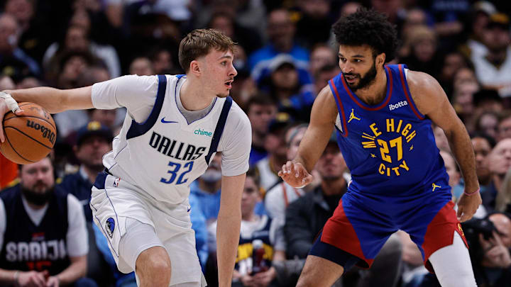 Dec 1, 2025; Denver, Colorado, USA; Dallas Mavericks forward Cooper Flagg (32) controls the ball as Denver Nuggets guard Jamal Murray (27) guards in the second quarter at Ball Arena. Dec 1, 2025; Denver, Colorado, USA; Dallas Mavericks forward Cooper Flagg (32) controls the ball as Denver Nuggets guard Jamal Murray (27) guards in the second quarter at Ball Arena.
