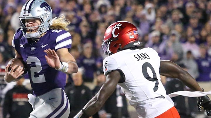 Nov 23, 2024; Manhattan, Kansas, USA; Kansas State Wildcats quarterback Avery Johnson (2) runs by Cincinnati Bearcats linebacker Jiquan Sanks (9) for a touchdown in the first quarter at Bill Snyder Family Football Stadium. Nov 23, 2024; Manhattan, Kansas, USA; Kansas State Wildcats quarterback Avery Johnson (2) runs by Cincinnati Bearcats linebacker Jiquan Sanks (9) for a touchdown in the first quarter at Bill Snyder Family Football Stadium.