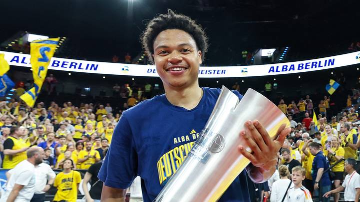 Jack Kayil (ALBA Berlin) celebrates with the championship trophy. Photo: Matthias Stickel/dpa