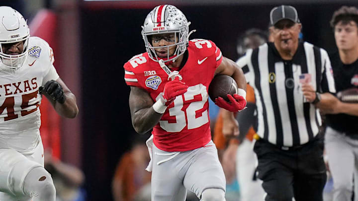Ohio State Buckeyes running back TreVeyon Henderson (32) gets away from Texas Longhorns defensive lineman Vernon Broughton (45) on run in the first quarter of the Cotton Bowl Classic during the College Football Playoff semifinal game at AT&T Stadium in Arlington, Texas on January, 10, 2025.