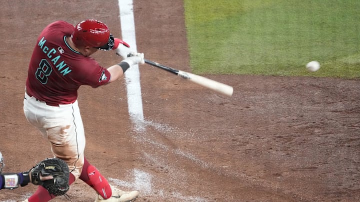 Aug 10, 2025; Phoenix, Arizona, USA; Arizona Diamondbacks catcher James McCann (8) hits an RBI single against the Colorado Rockies during the fifth inning at Chase Field. Mandatory Credit: Joe Camporeale-Imagn Images
