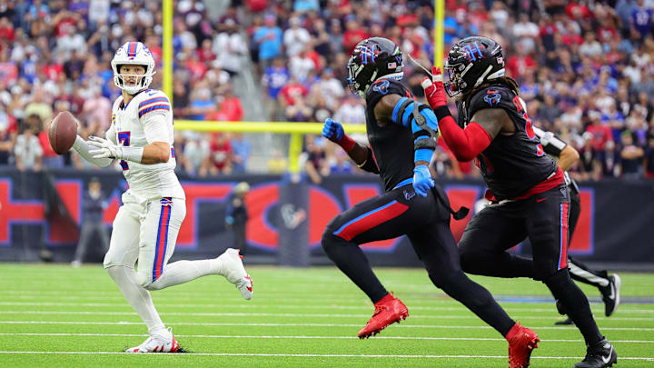 Josh Allen runs away from a pair of Houston Texans defenders