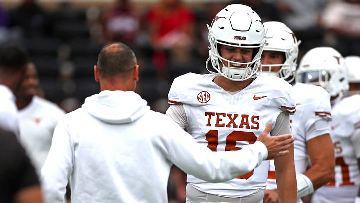 Texas Longhorns quarterback Arch Manning runs the ball with head coach Steve Sarkisian during warm-ups.