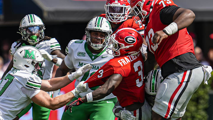 Aug 30, 2025; Athens, Georgia, USA; Marshall Thundering Herd linebacker Cannon Lewis (27) grabs the jersey of Georgia Bulldogs running back Nate Frazier (3) during the first half at Sanford Stadium. Mandatory Credit: Dale Zanine-Imagn Images