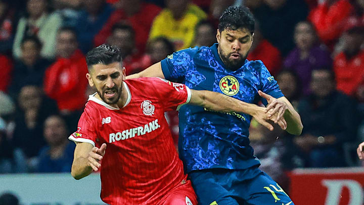 El portugués Paulinho Dias del Toluca y Néstor Araujo del América compiten por el esférico.