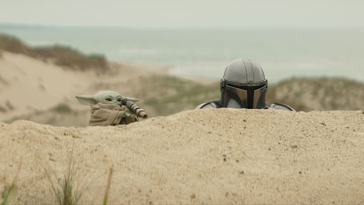 (L-R) Grogu and Mandalorian (Pedro Pascal) in Lucasfilm's THE MANDALORIAN & GROGU. Photo courtesy of Lucasfilm. © 2025 Lucasfilm Ltd™. All Rights Reserved.