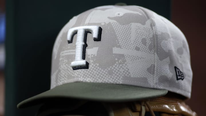 May 18, 2025; Arlington, Texas, USA; Texas Rangers hat in honor of the military in the dugout during the second inning against the Houston Astros at Globe Life Field. May 18, 2025; Arlington, Texas, USA; Texas Rangers hat in honor of the military in the dugout during the second inning against the Houston Astros at Globe Life Field.