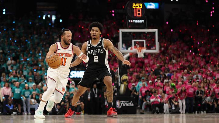 Jun 3, 2026; San Antonio, Texas, USA; New York Knicks guard Jalen Brunson (11) dribbles the ball past San Antonio Spurs guard Dylan Harper (2) in the first half during Game 1 of the 2026 NBA Finals at Frost Bank Center.