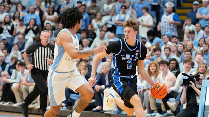 Duke Blue Devils forward Cooper Flagg dribbles as North Carolina Tar Heels guard Elliot Cadeau defends.