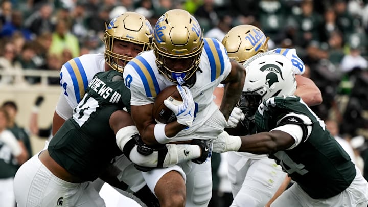 Oct 11, 2025; East Lansing, Michigan, USA; UCLA Bruins running back Jalen Berger (0) runs through the Michigan State defense in the second quarter at Spartan Stadium. Oct 11, 2025; East Lansing, Michigan, USA; UCLA Bruins running back Jalen Berger (0) runs through the Michigan State defense in the second quarter at Spartan Stadium.