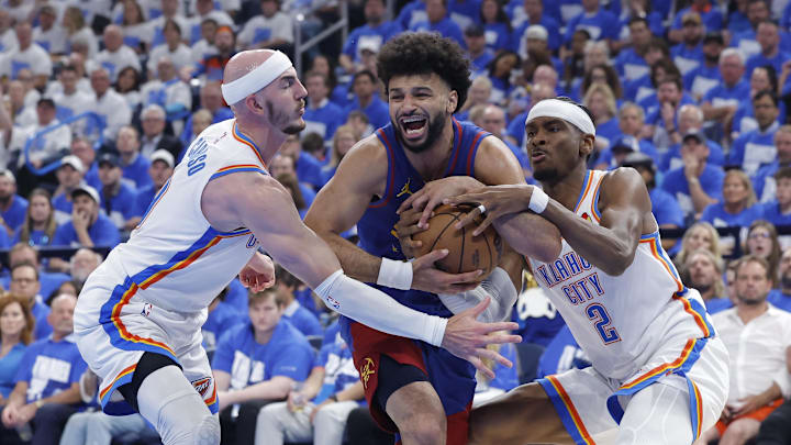 May 13, 2025; Oklahoma City, Oklahoma, USA; Denver Nuggets guard Jamal Murray (27) drives between Oklahoma City Thunder guard Alex Caruso (9) and guard Shai Gilgeous-Alexander (2) during the second quarter of game five of the second round for the 2025 NBA Playoffs at Paycom Center. Mandatory Credit: Alonzo Adams-Imagn Images
