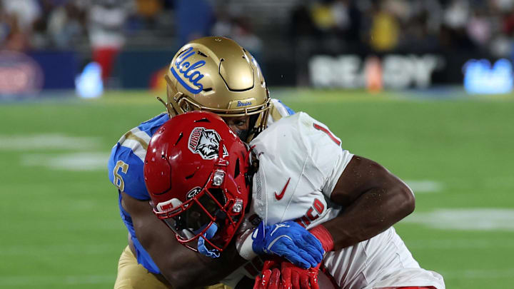 Sep 12, 2025; Pasadena, California, USA; New Mexico Lobos running back Damon Bankston (1) is tackled by UCLA Bruins linebacker JonJon Vaughns (6) during the second quarter at Rose Bowl. Mandatory Credit: Kiyoshi Mio-Imagn Images Sep 12, 2025; Pasadena, California, USA; New Mexico Lobos running back Damon Bankston (1) is tackled by UCLA Bruins linebacker JonJon Vaughns (6) during the second quarter at Rose Bowl. Mandatory Credit: Kiyoshi Mio-Imagn Images