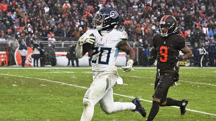 Dec 7, 2025; Cleveland, Ohio, USA; Tennessee Titans running back Tony Pollard (20) runs for a thirty-two yard touchdown against Cleveland Browns safety Grant Delpit (9) during the third quarter at Huntington Bank Field. Mandatory Credit: Ken Blaze-Imagn Images