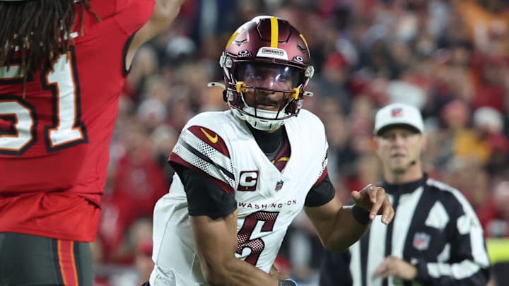 Jan 12, 2025; Tampa, Florida, USA; Washington Commanders quarterback Jayden Daniels (5) throws against Tampa Bay Buccaneers linebacker J.J. Russell (51) during the fourth quarter of a NFC wild card playoff at Raymond James Stadium. Mandatory Credit: Kim Klement Neitzel-Imagn Images
