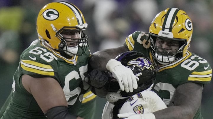 Green Bay Packers guard Aaron Banks (65) and offensive tackle Rasheed Walker (63) block Ravens defensive end Dre'Mont Jones.