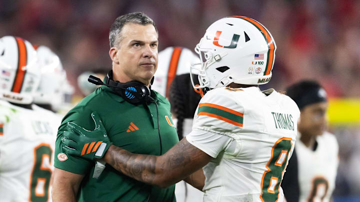 Jan 8, 2026; Glendale, AZ, USA; Miami Hurricanes head coach Mario Cristobal with defensive back Jakobe Thomas (8) against the Mississippi Rebels during the 2026 Fiesta Bowl and semifinal game of the College Football Playoff at State Farm Stadium. Mandatory Credit: Mark J. Rebilas-Imagn Images
