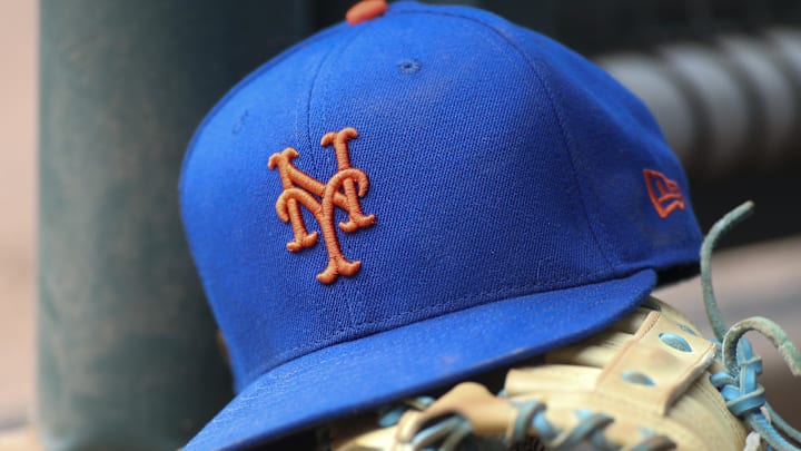 Jul 13, 2022; Atlanta, Georgia, USA; A detailed view of a New York Mets hat and glove in the dugout against the Atlanta Braves in the eighth inning at Truist Park. 