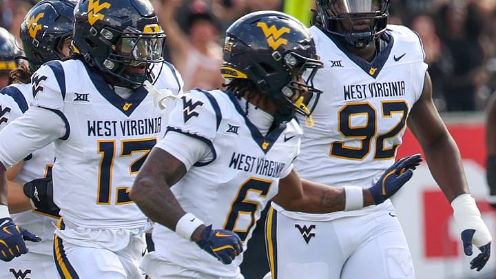 Nov 1, 2025; Houston, Texas, USA; Houston Cougars wide receiver Koby Young (18) is chased by West Virginia Mountaineers defensive back Jordan Scruggs (6) and teammates  in the first half at TDECU Stadium. Mandatory Credit: Thomas Shea-Imagn Images