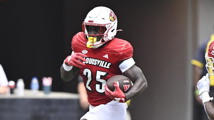 Aug 31, 2024; Louisville, Kentucky, USA;  Louisville Cardinals running back Isaac Brown (25) runs the ball against  Austin Peay Governors defensive back Cinque Williams (4) during the second quarter at L&N Federal Credit Union Stadium. Louisville defeated Austin Peay 62-0. Mandatory Credit: Jamie Rhodes-Imagn Images