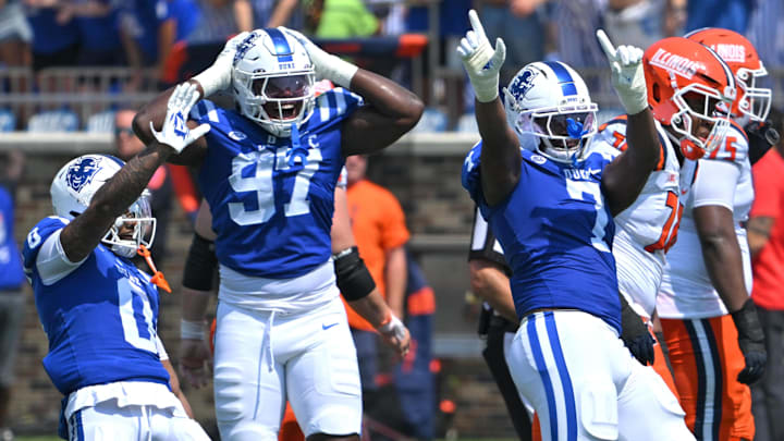 Sep 6, 2025; Durham, North Carolina, USA;  Duke Blue Devils cornerback Chandler Rivers (0), linebacker Jaiden Francois (2) and cornerback Kimari Robinson (5) celebrate a tackle by defensive end Vincent Anthony Jr.'s (7) against the Illinois Fighting Illini during the first quarter at Wallace Wade Stadium. Mandatory Credit: Zachary Taft-Imagn Images