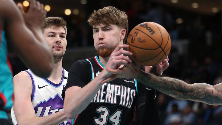 Feb 20, 2026; Memphis, Tennessee, USA; Memphis Grizzlies center Lawson Lovering (34) grabs a rebound between Utah Jazz forward Kyle Filipowski (22) and guard John Konchar (55) during the second quarter at FedExForum. Mandatory Credit: Petre Thomas-Imagn Images