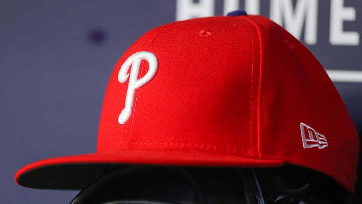 May 26, 2023; Atlanta, Georgia, USA; A detailed view of a Philadelphia Phillies hat and glove on the bench against the Atlanta Braves in the seventh inning at Truist Park. 