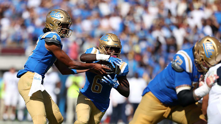 Oct 4, 2025; Pasadena, California, USA;  UCLA Bruins quarterback Nico Iamaleava (9) hands the ball off to running back Anthony Woods (6) during the third quarter against the Penn State Nittany Lions at Rose Bowl. Mandatory Credit: Kiyoshi Mio-Imagn Images