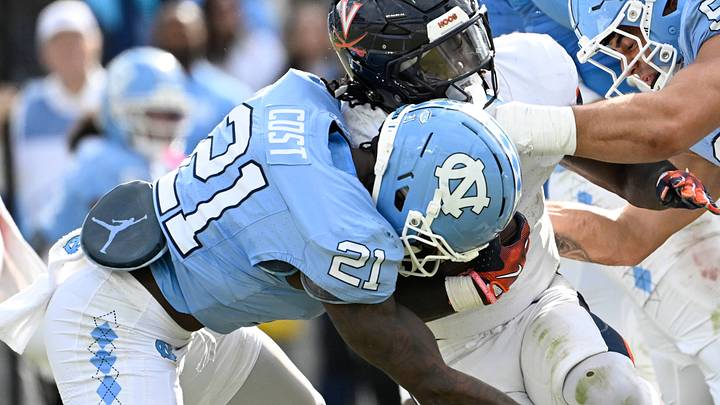 Oct 25, 2025; Chapel Hill, North Carolina, USA; Virginia Cavaliers running back J'Mari Taylor (3) with the ball as North Carolina Tar Heels defensive back Kaleb Cost (21) and defensive lineman Melkart Abou Jaoude (9) defend in overtime at Kenan Stadium. Mandatory Credit: Bob Donnan-Imagn Images Oct 25, 2025; Chapel Hill, North Carolina, USA; Virginia Cavaliers running back J'Mari Taylor (3) with the ball as North Carolina Tar Heels defensive back Kaleb Cost (21) and defensive lineman Melkart Abou Jaoude (9) defend in overtime at Kenan Stadium. Mandatory Credit: Bob Donnan-Imagn Images