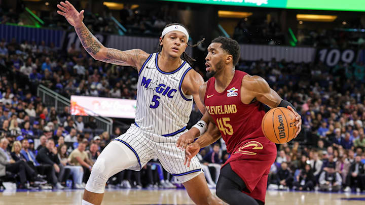 Jan 24, 2026; Orlando, Florida, USA; Cleveland Cavaliers guard Donovan Mitchell (45) drives around Orlando Magic forward Paolo Banchero (5) during the second half at Kia Center. Mandatory Credit: Mike Watters-Imagn Images