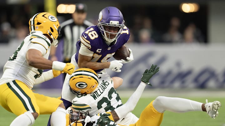 Jan 4, 2026; Minneapolis, Minnesota, USA; Minnesota Vikings wide receiver Justin Jefferson (18) runs with the ball against Green Bay Packers safety Evan Williams (33) during the first quarter at U.S. Bank Stadium