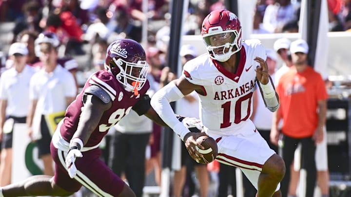 Oct 26, 2024; Starkville, Mississippi, USA; Arkansas Razorbacks quarterback Taylen Green (10) runs the ball while defended by Mississippi State Bulldogs defensive lineman Deonte Anderson (91) during the second quarter at Davis Wade Stadium at Scott Field. Mandatory Credit: Matt Bush-Imagn Images