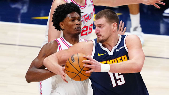 Dec 15, 2025; Denver, Colorado, USA; Denver Nuggets center Nikola Jokic (15) drives at Houston Rockets guard Amen Thompson (1) in the third quarter at Ball Arena.