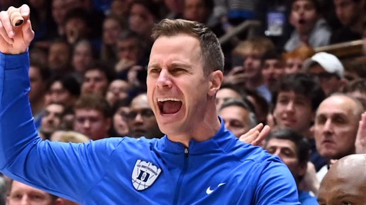 Feb 28, 2026; Durham, North Carolina, USA;Duke Blue Devils head coach Jon Scheyer (left) reacts during the first half against the Virginia Cavaliers at Cameron Indoor Stadium. Mandatory Credit: Rob Kinnan-Imagn Images
