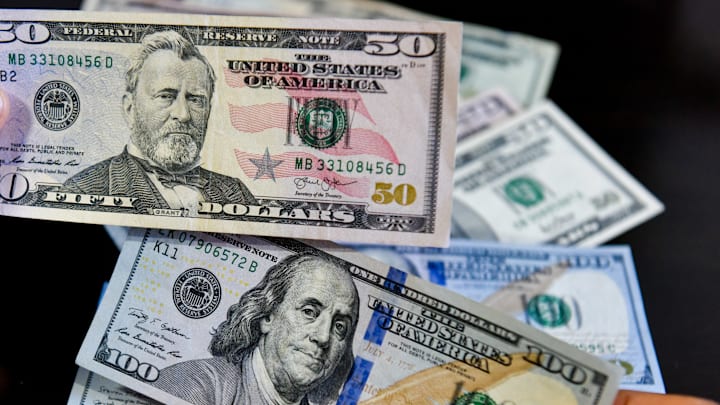 In this photo illustration, a person seen holding 50 and 100...