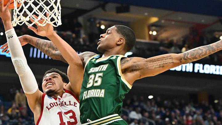 Mar 19, 2026; Buffalo, NY, USA; Louisville Cardinals forward Sananda Fru (13) shoots a lay up as South Florida Bulls forward Izaiyah Nelson (35) defends during the first half during a first round game of the men's 2026 NCAA Tournament at Keybank Center. Mandatory Credit: Mark Konezny-Imagn Images