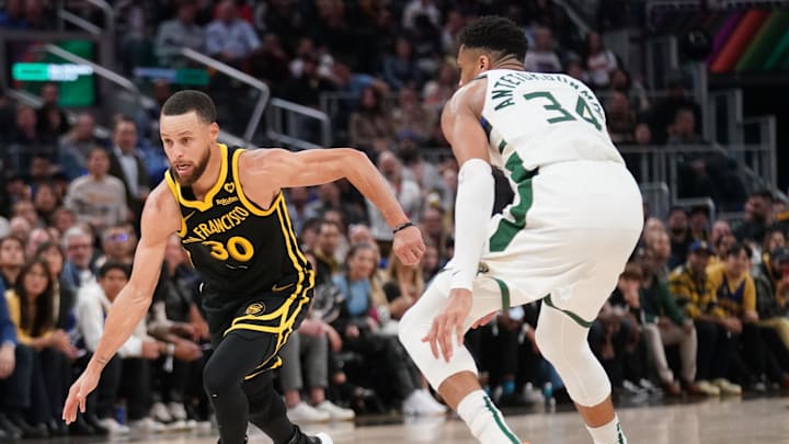 Mar 6, 2024; San Francisco, California, USA; Golden State Warriors guard Stephen Curry (30) dribbles past Milwaukee Bucks forward Giannis Antetokounmpo (34) in the third quarter at Chase Center.