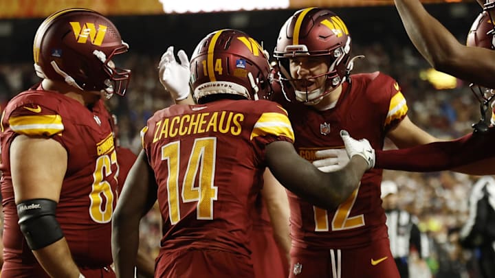 Dec 29, 2024; Landover, Maryland, USA; Washington Commanders wide receiver Olamide Zaccheaus (14) celebrates with teammates after scoring a touchdown against the Atlanta Falcons during the first quarter at Northwest Stadium. Mandatory Credit: Geoff Burke-Imagn Images