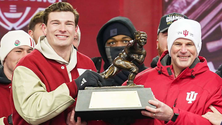 Jan 24, 2026; Bloomington, IN, USA; Indiana Hoosiers quarterback Fernando Mendoza (15) holds the Heisman Trophy with Indiana Hoosiers head coach Curt Cignetti on Saturday, Jan. 24, 2026, during the Indiana Football College Football Playoff National Championship celebration and parade at Memorial Stadium. Mandatory Credit: Grace Hollars-USA TODAY Network via Imagn Images