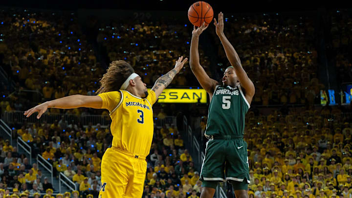 Feb 21, 2025; Ann Arbor, MI, USA; Michigan State player Tre Holloman (5) shoots over Michigan player Tre Donaldson (3) during the first half of their matchup at Crisler Center. Mandatory Credit: David Rodriguez Munoz-Imagn Images Feb 21, 2025; Ann Arbor, MI, USA; Michigan State player Tre Holloman (5) shoots over Michigan player Tre Donaldson (3) during the first half of their matchup at Crisler Center. Mandatory Credit: David Rodriguez Munoz-Imagn Images