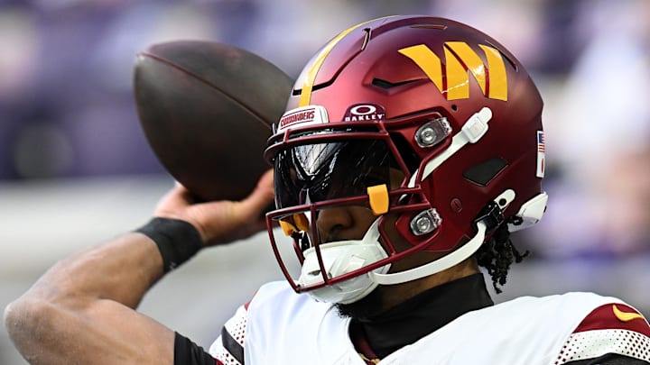 Washington Commanders quarterback Jayden Daniels practices before the game at U.S. Bank Stadium.